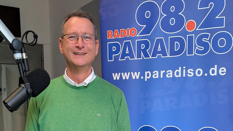 Ralf Schäfer, Beauftragter für Diversität und queere Lebensweisen der Immanuel Albertinen Diakonie, Sparte Wohnen und Pflegen, im Studio von Radio Paradiso vor einem Mikrofon