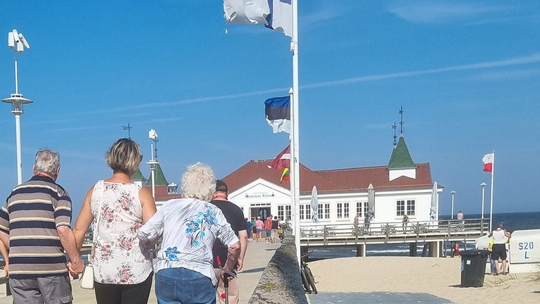 Pflegekraft mit Bewohner und Bewohnerin auf der Seebrücke Pflegekraft mit Bewohner und Bewohnerin auf der Seebrücke