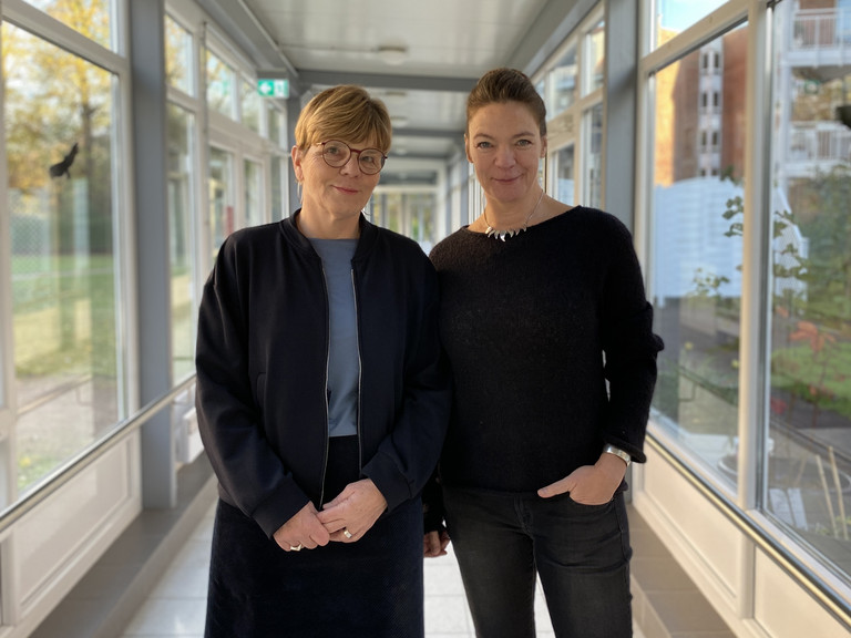 Sabine Kalkhoff (links) und Valeska Stephanow stehen nebeneinander und blicken in die Kamera beim Workshop zum Thema „Spracherwerb in der Pflege“ für Praxisanleitende der Residenz am Wiesenkamp und im Feierabendhaus Volksdorf
