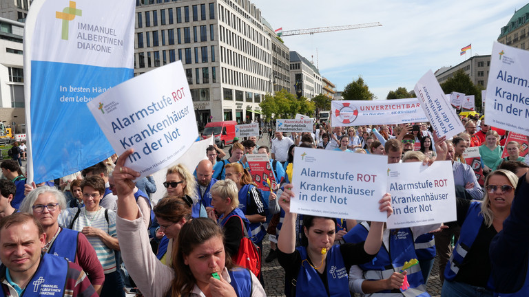 Protestierende stehen mit Plakaten und Pfeifen auf der Straße, Krankenhausreform, Immanuel Albertinen Diakonie, Hamburg, Berlin Protestierende stehen mit Plakaten und Pfeifen auf der Straße, Krankenhausreform, Immanuel Albertinen Diakonie, Hamburg, Berlin