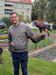 Ein Mann mit Falknerhanschuh und einem Adler auf dem Arm blickt in die Kamera beim Festakt zum 25-jährigen Jubiläum des Immanuel Suchthilfeverbunds Guben mit besonderen Wohnformen für abhängigkeitskranke Menschen in Thüringen