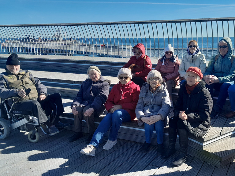 Gruppe blickt am Ostseestrand in die Kamera bei Gruppenreise nach Zinnowitz an der Ostsee