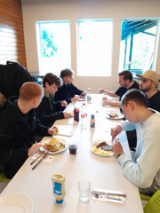 Auszubildende sitzen an einem Tisch und essen Auszubildende sitzen an einem Tisch und essen