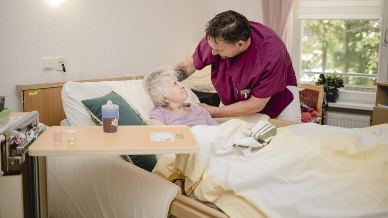 Ein Pfleger unterhält sich mit einer Seniorin im Pflegezimmer im Seniorenzentrum Kläre Weist in Petershagen Ein Pfleger unterhält sich mit einer Seniorin im Pflegezimmer im Seniorenzentrum Kläre Weist in Petershagen