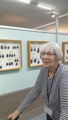 Eine Seniorin blickt in die Kamera bei einer Ausstellung bei Gruppenreise nach Zinnowitz an der Ostsee