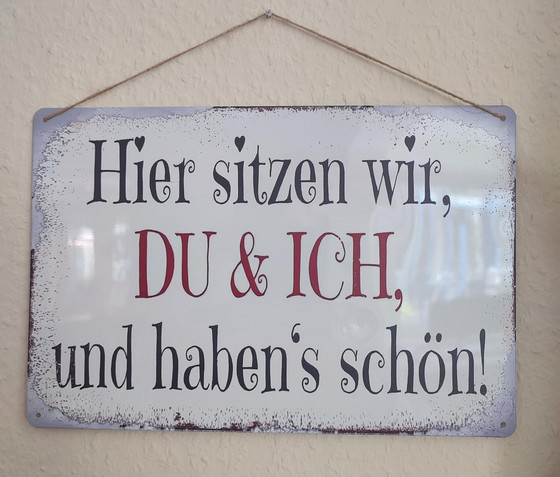 Ein Schild mit der Aufschrift "Hier sitzen wir, Du und Ich, und haben´s schön" hängt im Büro in der Verwaltung der Senioreneinrichtung Immanuel Haus Ecktannen in Waren (Müritz) Ein Schild mit der Aufschrift "Hier sitzen wir, Du und Ich, und haben´s schön" hängt im Büro in der Verwaltung der Senioreneinrichtung Immanuel Haus Ecktannen in Waren (Müritz)