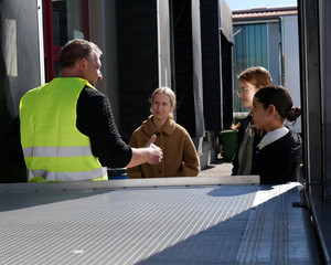Schülerinnen im Gespräch mit Logistiker an einem LKW beim Girls’ Day bei der Albertinen Services Hamburg in Rellingen