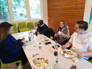 Auszubildende sitzen an einem Tisch und essen Auszubildende sitzen an einem Tisch und essen