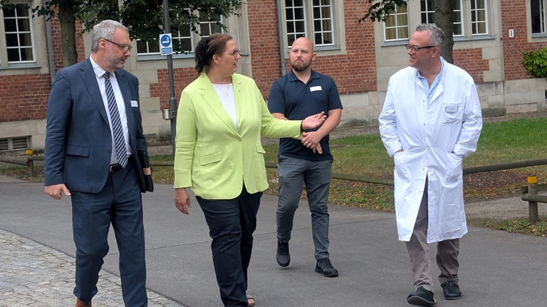 Roy J. Noack, Ellen Haußdörfer, Martin Baumann und Dr. Udo Schneider beim Rundgang über den Campus