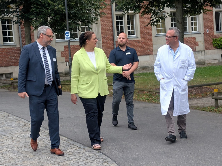 Roy J. Noack, Ellen Haußdörfer, Martin Baumann und Dr. Udo Schneider beim Rundgang über den Campus