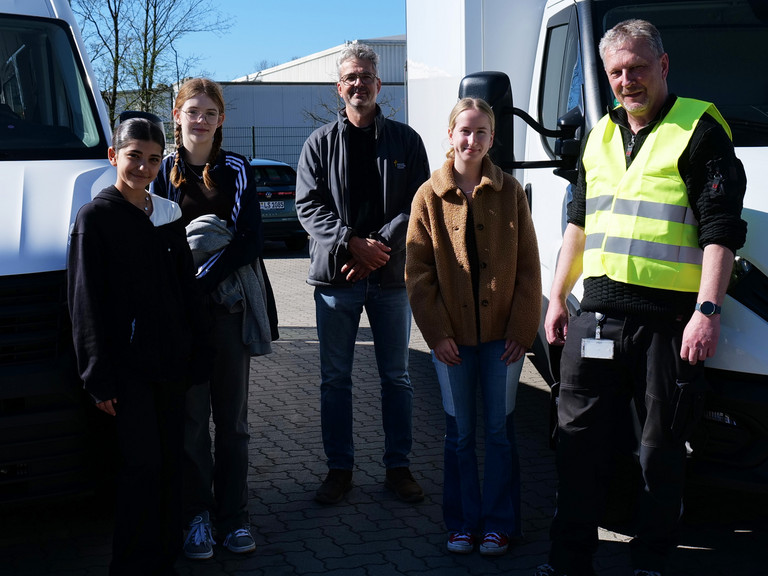 Gruppenfoto zwischen zwei Fahrzeugen beim Girls’ Day bei der Albertinen Services Hamburg in Rellingen