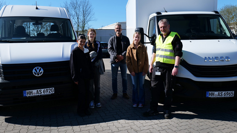 Gruppenfoto zwischen zwei Fahrzeugen beim Girls’ Day bei der Albertinen Services Hamburg in Rellingen, Girls und Boys Day, Schnupperpraktikum Schülerinnen und Schüler, Ausbildung, Karriere, Zentralküche, Logistik, Schleswig-Holstein Gruppenfoto zwischen zwei Fahrzeugen beim Girls’ Day bei der Albertinen Services Hamburg in Rellingen