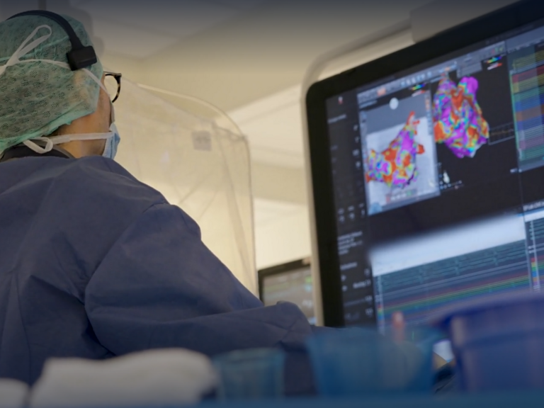 PD Dr. Benjamin Schäffer, Leitender Arzt Elektrophysiologie im Albertinen Herz- und Gefäßzentrum, blickt während einer Operation auf einen großen Monitor mit medizinischen Daten im Albertinen Krankenhaus in Hamburg