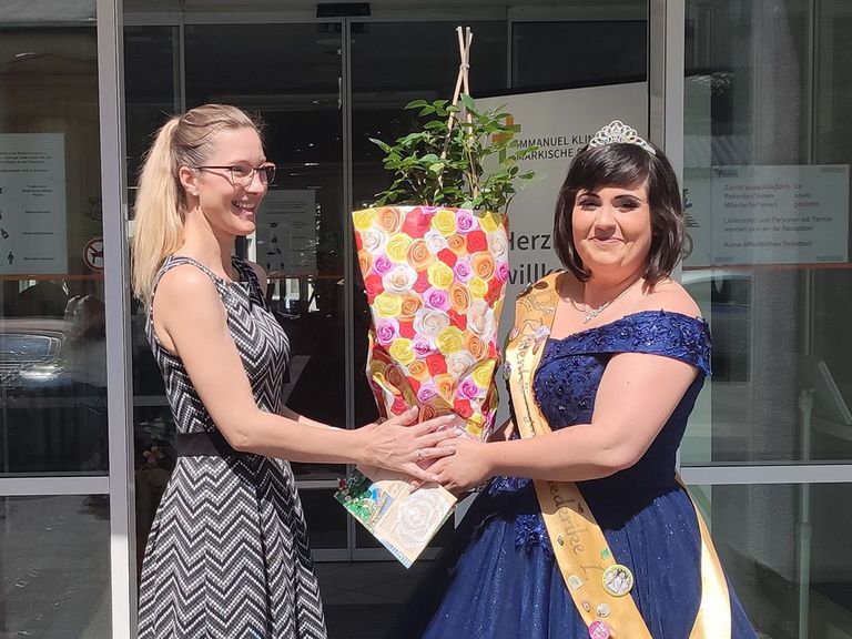 Immanuel Klinik Märkische Schweiz - Nachricht - Buckower Rosentage - Rosenkönigin Friedericke I übergibt Maria Jentsch eine Strauchrose