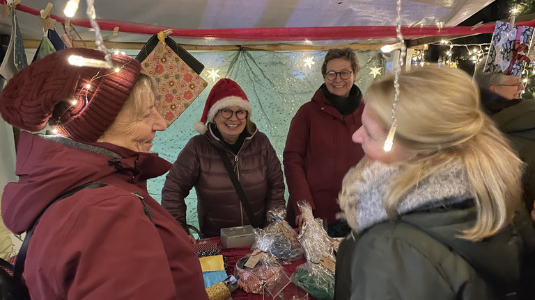 Hospizmitarbeitende und -gäste an einem Adventsmarktstand, Veranstaltung im Hospiz, Weihnachtsmarkt für Mitarbeitende und Gäste im Hospiz, Diakonie Hospiz Wannsee, Berlin-Wannsee Hospizmitarbeitende und -gäste an einem Adventsmarktstand, Veranstaltung im Hospiz, Weihnachtsmarkt für Mitarbeitende und Gäste im Hospiz, Diakonie Hospiz Wannsee, Berlin-Wannsee