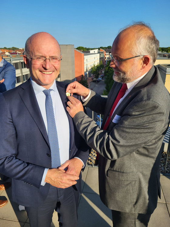 Landrat Daniel Kurth steckt Dr. med. Georg Fritz die Nadel an