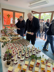 Menschen stehen vor dem Festbuffet bei der Feier zum 25-jährigen Jubiläum des Immanuel Suchthilfeverbunds Guben mit besonderen Wohnformen für abhängigkeitskranke Menschen in Thüringen