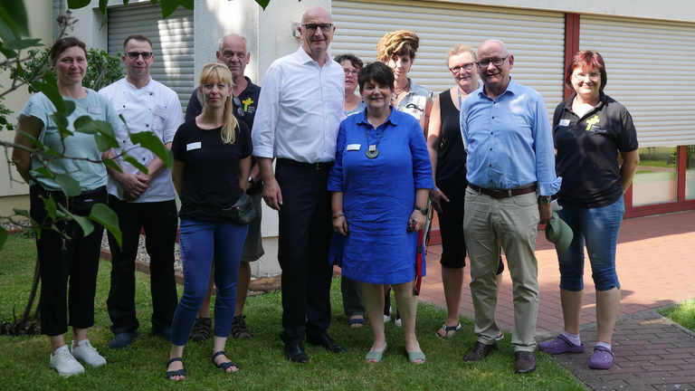 Brandenburgs Ministerpräsident Dietmar Woidke auf einem Gruppenfoto mit Mitarbeitenden beim Besuch des Immanuel Suchthilfeverbunds Guben, Hilfe und Therapie bei Suchterkrankungen in Brandenburg, Immanuel-Miteinander Leben Brandenburgs Ministerpräsident Dietmar Woidke auf einem Gruppenfoto mit Mitarbeitenden beim Besuch des Immanuel Suchthilfeverbunds Guben