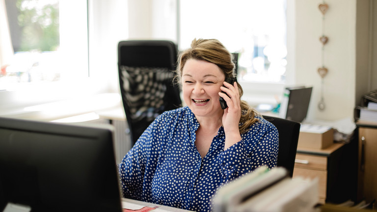 Eine Verwaltungsmitarbeiterin sitzt an einem Schreibtisch und blickt mit einem Telefonhörer in der Hand auf einen Monitor in der Verwaltung der Senioreneinrichtung Immanuel Haus Ecktannen in Waren (Müritz) Eine Verwaltungsmitarbeiterin sitzt an einem Schreibtisch und blickt mit einem Telefonhörer in der Hand auf einen Monitor in der Verwaltung der Senioreneinrichtung Immanuel Haus Ecktannen in Waren (Müritz)