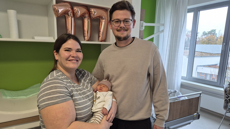 Hebamme mit Mutter, die das Baby im Arm hält und Vater in der Immanuel Klinik Rüdersdorf
