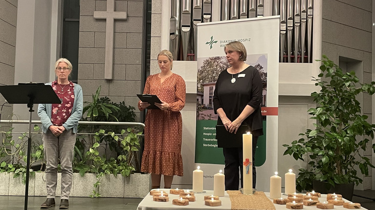 Pastorin Nicole Witzemann und zwei Mitarbeiterinnen auf der Bühne in der Kirche, Gottesdienst in Gedenken an die Verstorbenen, Ambulanter Hospizdienst, stationäres Hospiz, Diakonie Hospiz Wannsee, Berlin Pastorin Witzemann und zwei Mitarbeiterinnen auf der Bühne in der Kirche, Gottesdienst in Gedenken an die Verstorbenen, Ambulanter Hospizdienst, stationäres Hospiz, Diakonie Hospiz Wannsee, Berlin