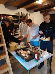 Auszubildende nehmen sich Essen von einem Tisch Auszubildende nehmen sich Essen von einem Tisch