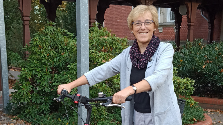 Rita Burmeister stehend mit dem Fahrrad an der Hand, Hospiz- und Palliativdienst, Begleitung sterbender Menschen, Diakonie Hospiz Wannsee, Interview, Berlin-Wannsee Rita Burmeister stehend mit dem Fahrrad an der Hand, Hospiz- und Palliativdienst, Begleitung sterbender Menschen, Diakonie Hospiz Wannsee, Interview, Berlin-Wannsee
