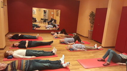 Gruppe in einem Raum bei einer Yogaübung auf Yogamatten bei Gruppenreise nach Zinnowitz