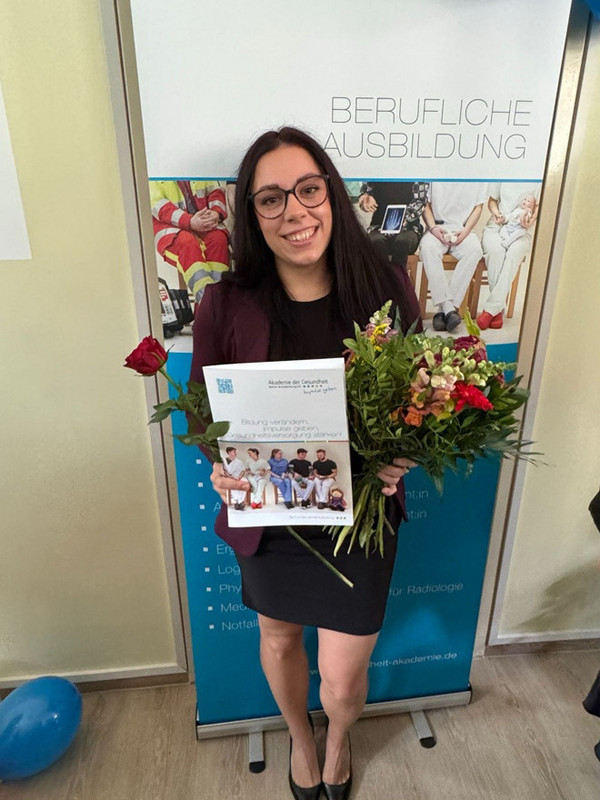 Operationstechnische Assistenz mit Blumenstrauß Operationstechnische Assistenz mit Blumenstrauß