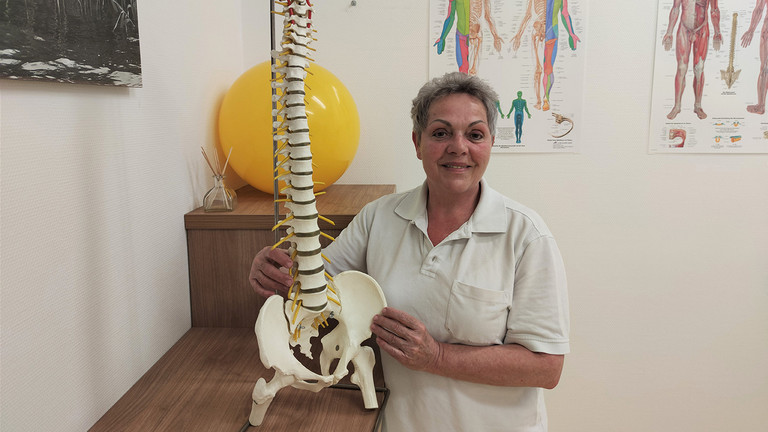 Immanuel Klinik Rüdersdorf - Nachricht - Erfolgsgeschichten aus Rüdersdorf: 47 Jahre als Physiotherapeutin in Rüdersdorf - Annett Lubkowski mit einen Modell der Wirbelsäule in einem der modernen Behandlungsräume der Klinik Immanuel Klinik Rüdersdorf - Nachricht - Erfolgsgeschichten aus Rüdersdorf: 47 Jahre als Physiotherapeutin in Rüdersdorf - Annett Lubkowski mit einen Modell der Wirbelsäule in einem der modernen Behandlungsräume der Klinik