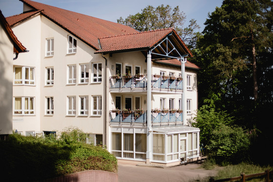 Blick auf das Gebäude mit Bäumen und Pflanzen im Vordergrund und Balkonen mit Blumen der Senioreneinrichtung Immanuel Haus Ecktannen in Waren (Müritz) Blick auf das Gebäude mit Bäumen und Pflanzen im Vordergrund und Balkonen mit Blumen der Senioreneinrichtung Immanuel Haus Ecktannen in Waren (Müritz)