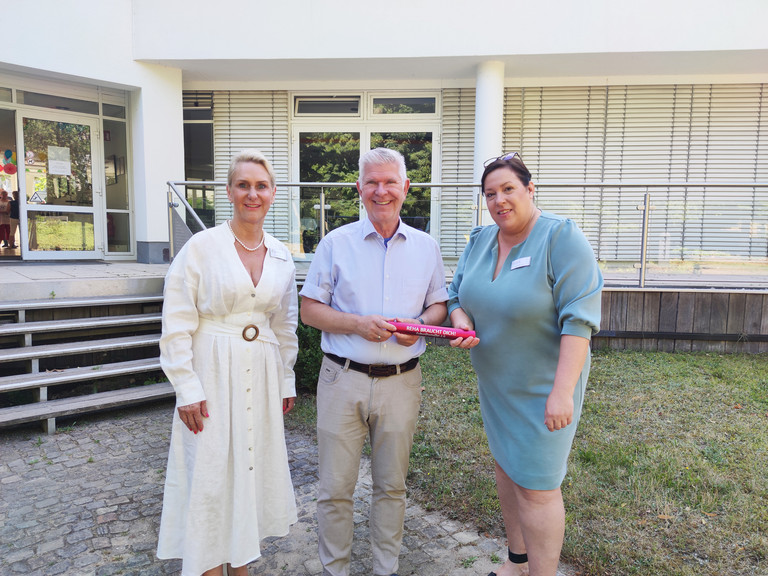 Dr. med. Diana Lüftner, Annette Binder mit Thomas Mix stehen auf einem Weg vor dem Gebäude